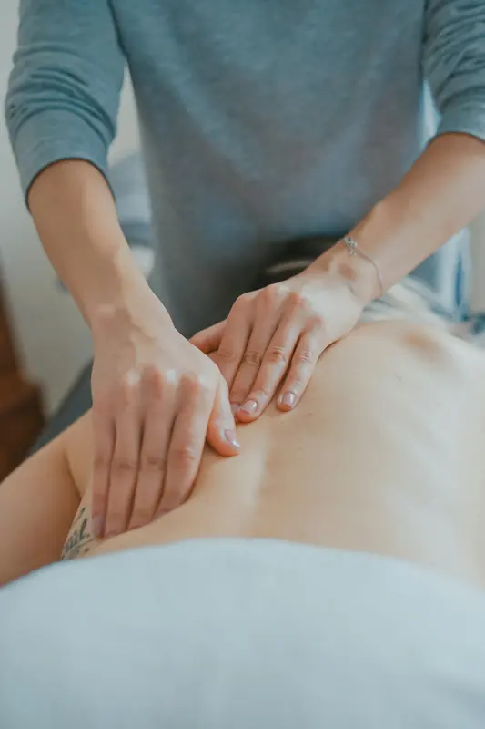 Mãos realizando massagem nas costas