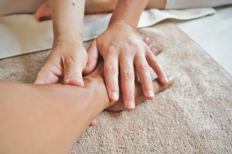 Mãos fazendo massagem delicada sobre uma toalha macia